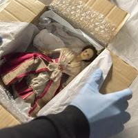 Unpacking treasures from the 18th century Doll's House at Nostell Priory, West Yorkshire. ©National Trust Images/Paul Harris. Image depicts the unpacking of a 18th century doll's house doll wearing a lace embroidered red gown (Nostell Priory, West Yorkshire).